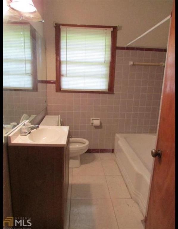 1410 Willis Mill Rd SW, Atlanta, GA 30311 - bathroom featuring vanity, tile walls, tile patterned floors, a wainscoted wall, and  shower combination