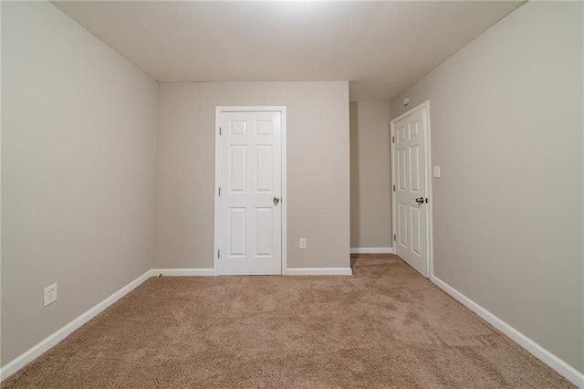 spare room featuring light carpet