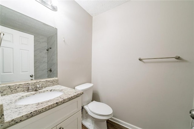 bathroom featuring hardwood / wood-style floors, vanity, toilet, and a textured ceiling