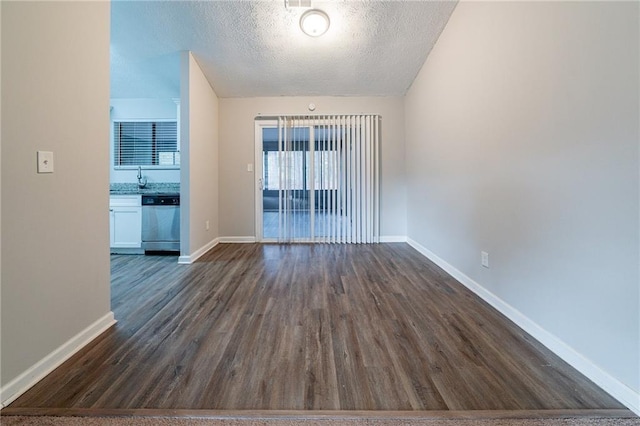 unfurnished room featuring sink, dark hardwood / wood-style flooring, and a textured ceiling