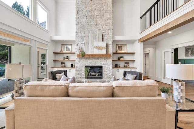 2335 Flat Stone Dr, Cumming, GA 30041 - living room featuring a stone fireplace, a healthy amount of sunlight, a towering ceiling, and wood finished floors