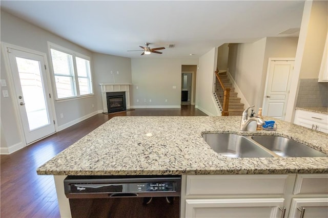 2034 W Hampton Dr, Canton, GA 30115 - kitchen with white cabinets, dishwasher, a sink, ceiling fan, and a fireplace with flush hearth