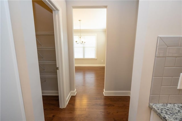 2034 W Hampton Dr, Canton, GA 30115 - hall featuring dark wood-type flooring, baseboards, and a notable chandelier