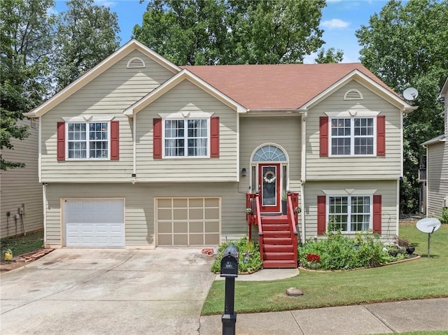 split foyer home featuring an attached garage, driveway, and a front yard