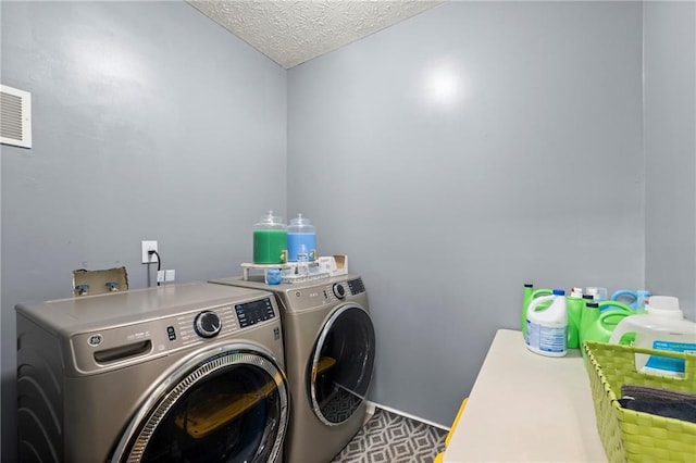 washroom with laundry area, visible vents, a textured ceiling, and separate washer and dryer