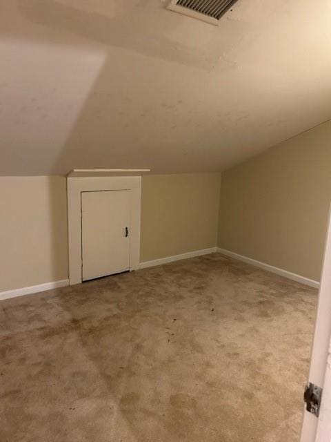 additional living space with carpet floors and vaulted ceiling