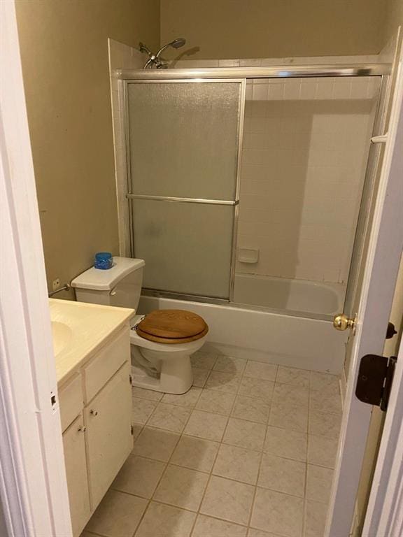 full bathroom featuring tile patterned flooring, bath / shower combo with glass door, toilet, and vanity