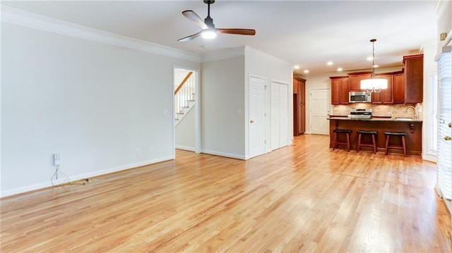 251 Waterford Cove Dr, Suwanee, GA 30024 - living room featuring baseboards, light wood-style flooring, a ceiling fan, stairway, and ornamental molding