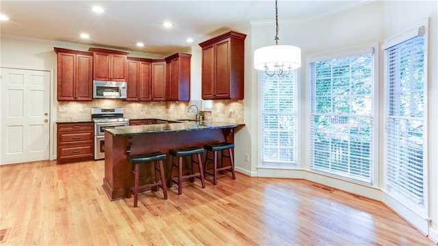 251 Waterford Cove Dr, Suwanee, GA 30024 - kitchen with appliances with stainless steel finishes, a sink, light wood finished floors, backsplash, and ornamental molding
