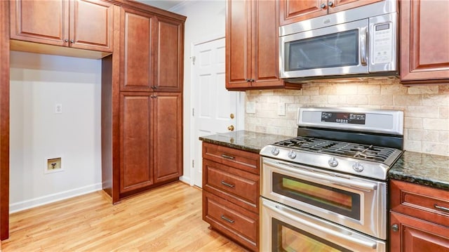 251 Waterford Cove Dr, Suwanee, GA 30024 - kitchen with stainless steel appliances, dark stone countertops, decorative backsplash, and light wood-style flooring