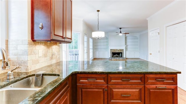251 Waterford Cove Dr, Suwanee, GA 30024 - kitchen with a sink, a ceiling fan, a peninsula, tasteful backsplash, and a fireplace with raised hearth