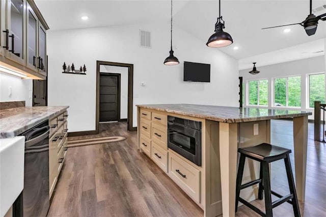 kitchen featuring vaulted ceiling, dark wood finished floors, a breakfast bar area, light stone countertops, and recessed lighting