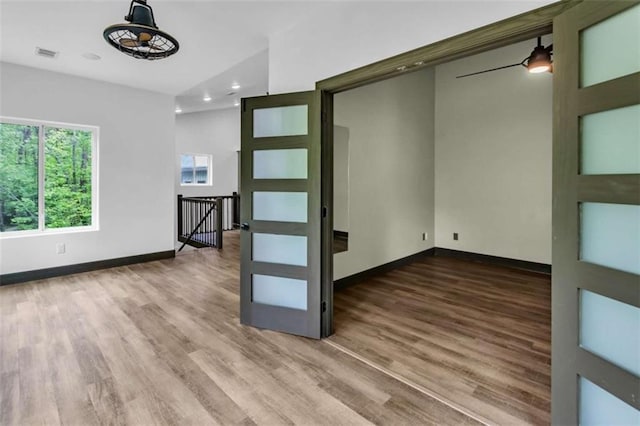 empty room featuring wood finished floors, baseboards, and recessed lighting