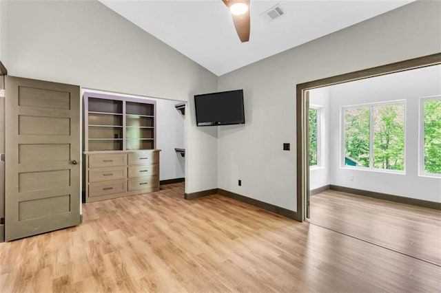 unfurnished bedroom with light wood-style floors, baseboards, a ceiling fan, and high vaulted ceiling