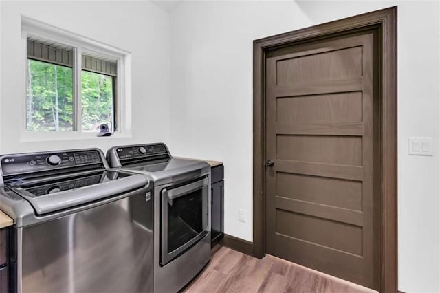 laundry room featuring independent washer and dryer and light wood-style floors