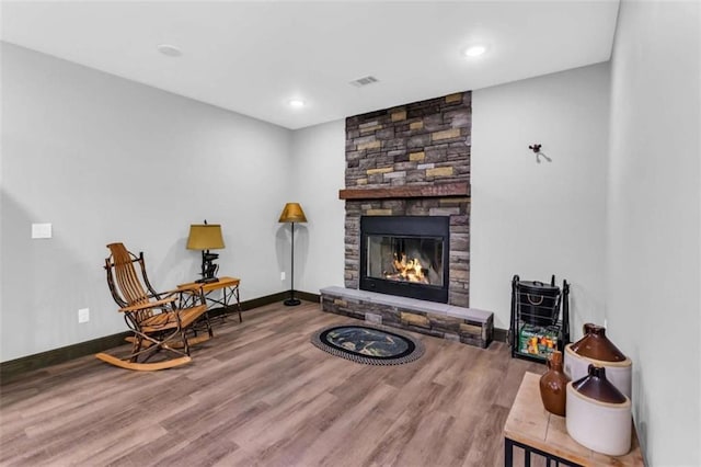 living area with wood finished floors, a fireplace, baseboards, and recessed lighting