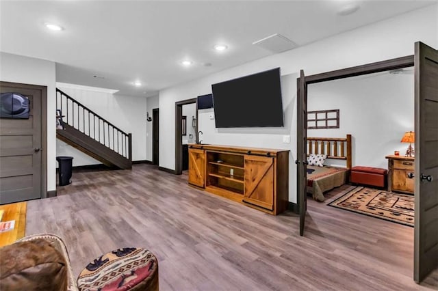 living area featuring stairs, light wood finished floors, recessed lighting, and baseboards