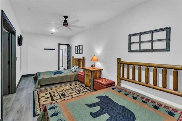 bedroom featuring wood finished floors, baseboards, and ceiling fan