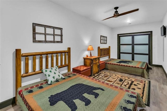 bedroom with wood finished floors, baseboards, and a ceiling fan