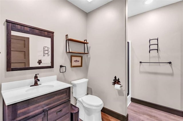 full bath with wood finished floors, toilet, vanity, a shower, and baseboards