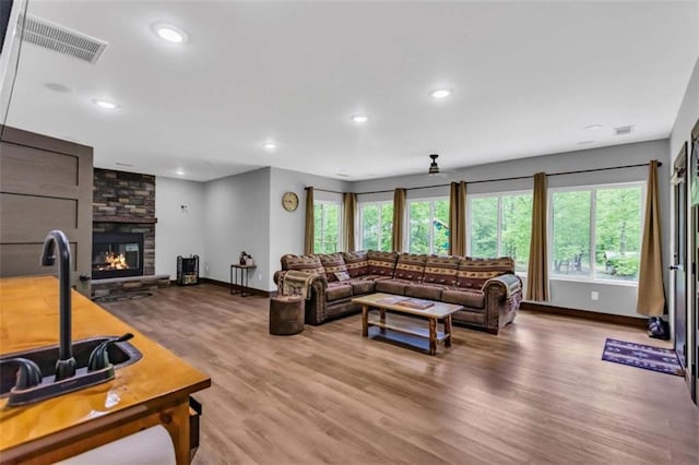 living area with baseboards, plenty of natural light, wood finished floors, and recessed lighting