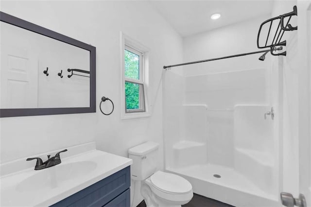 bathroom with a shower, vanity, and toilet