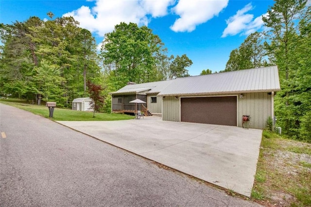 ranch-style home with a storage unit, a front lawn, and metal roof