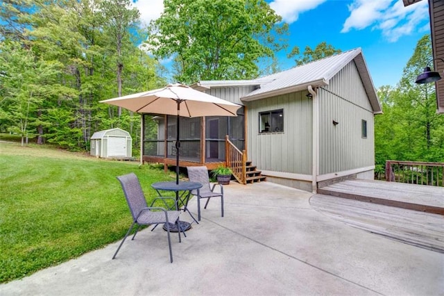 rear view of property featuring a storage shed, a patio area, an outdoor structure, a yard, and a sunroom