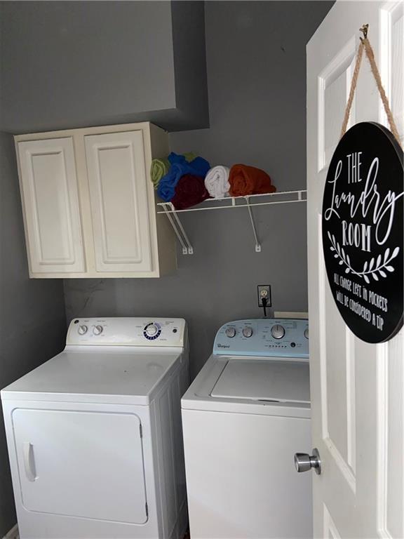 washroom featuring cabinet space and independent washer and dryer