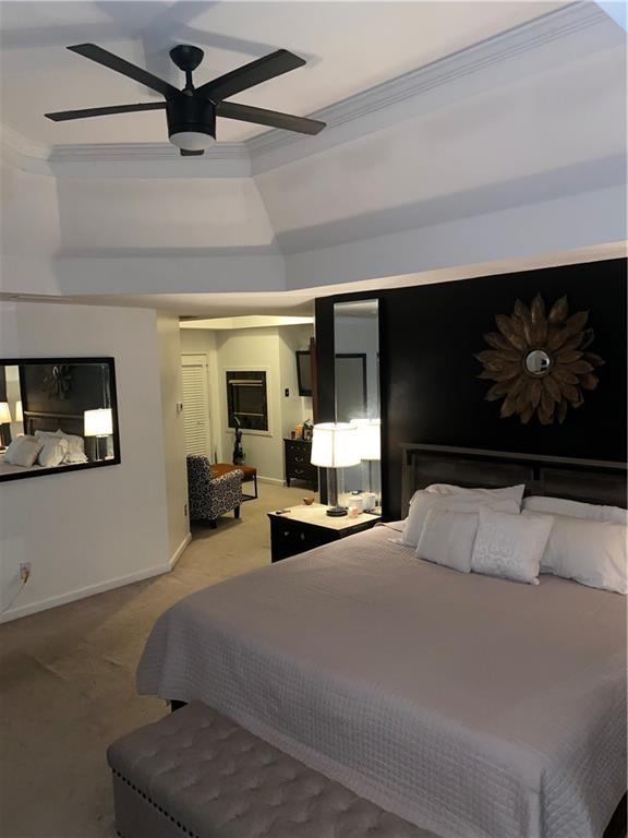 bedroom with ceiling fan, ornamental molding, carpet, and baseboards