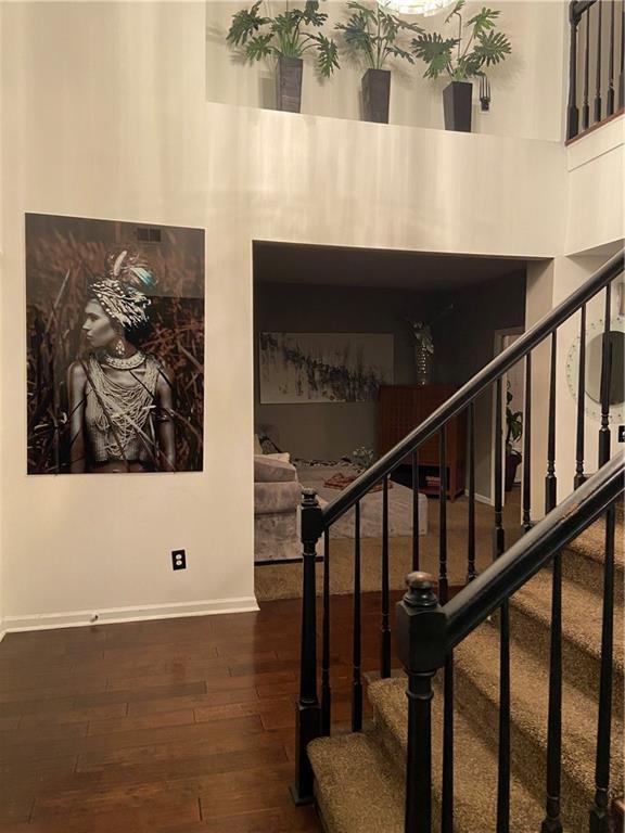 stairway featuring baseboards and hardwood / wood-style floors