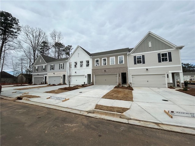 view of front of home featuring driveway, a garage, board and batten siding, and brick siding