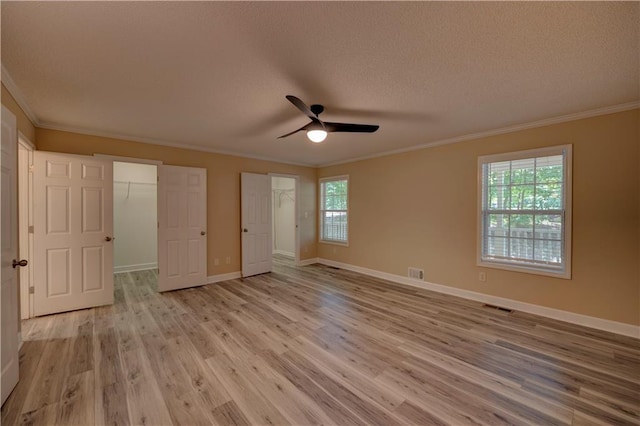 535 Toonigh Rd, Woodstock, GA 30188 - unfurnished bedroom with ornamental molding, light wood-type flooring, a textured ceiling, baseboards, and a ceiling fan