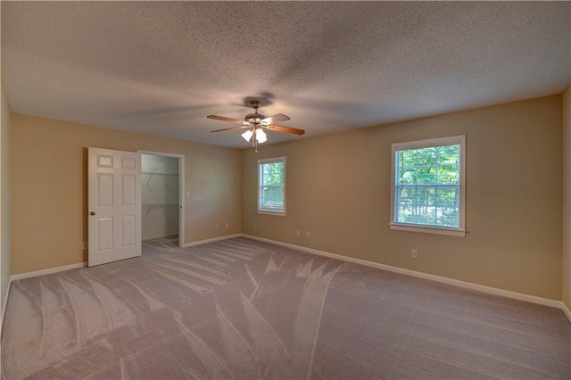 535 Toonigh Rd, Woodstock, GA 30188 - unfurnished bedroom with carpet, baseboards, a spacious closet, a textured ceiling, and ceiling fan