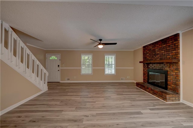 535 Toonigh Rd, Woodstock, GA 30188 - unfurnished living room with a textured ceiling, crown molding, light wood finished floors, stairs, and a ceiling fan