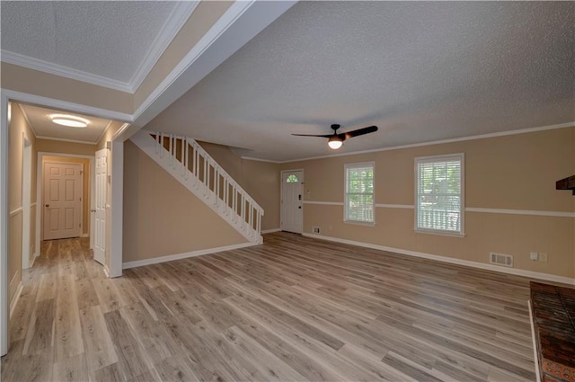 535 Toonigh Rd, Woodstock, GA 30188 - unfurnished living room featuring a textured ceiling, stairs, light wood-style floors, ceiling fan, and crown molding
