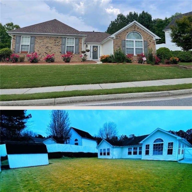 rear view of property featuring a lawn and brick siding