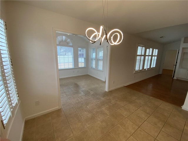 unfurnished dining area featuring light tile patterned flooring, baseboards, and a chandelier