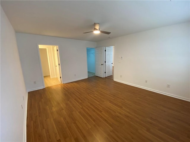 unfurnished room with dark wood finished floors, baseboards, and ceiling fan