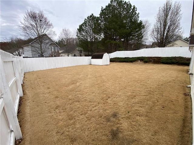 view of yard with an outbuilding, a storage shed, and a fenced backyard