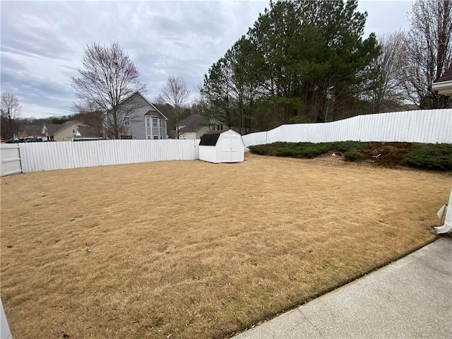 view of yard featuring an outbuilding, a fenced backyard, and a shed