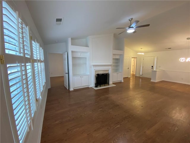 unfurnished living room with lofted ceiling, dark wood-type flooring, and a fireplace with raised hearth