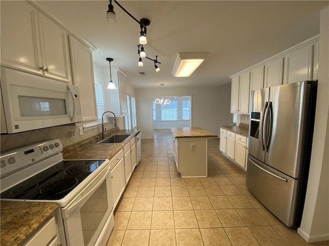 kitchen featuring a sink, white appliances, backsplash, and white cabinets