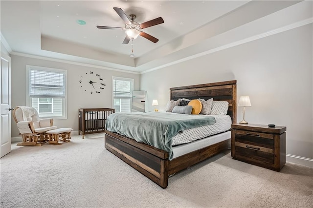 bedroom featuring carpet, a tray ceiling, ceiling fan, and ornamental molding