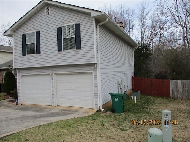 view of property exterior with a garage, driveway, and fence