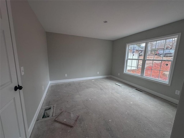 unfurnished room with visible vents and baseboards