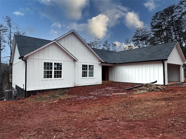 exterior space featuring a shingled roof, central AC, and board and batten siding