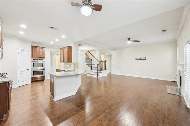 2760 Lions Gate Dr, Cumming, GA 30041 - kitchen featuring ceiling fan, double oven, crown molding, open floor plan, and a peninsula