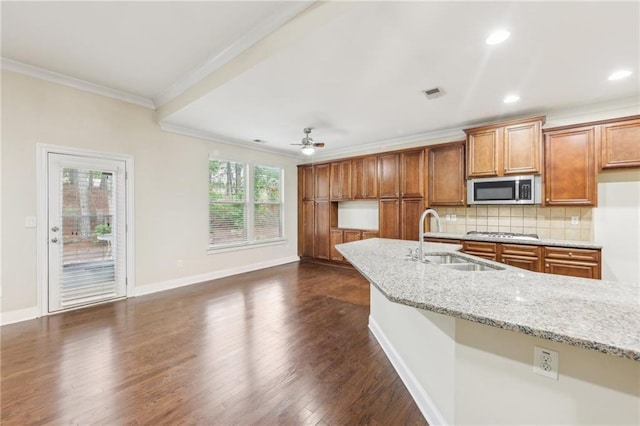 2760 Lions Gate Dr, Cumming, GA 30041 - kitchen featuring appliances with stainless steel finishes, a sink, ornamental molding, brown cabinetry, and tasteful backsplash