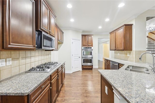2760 Lions Gate Dr, Cumming, GA 30041 - kitchen featuring stainless steel appliances, a sink, light stone counters, wood finished floors, and recessed lighting